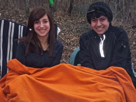 teens at campfire under blanket