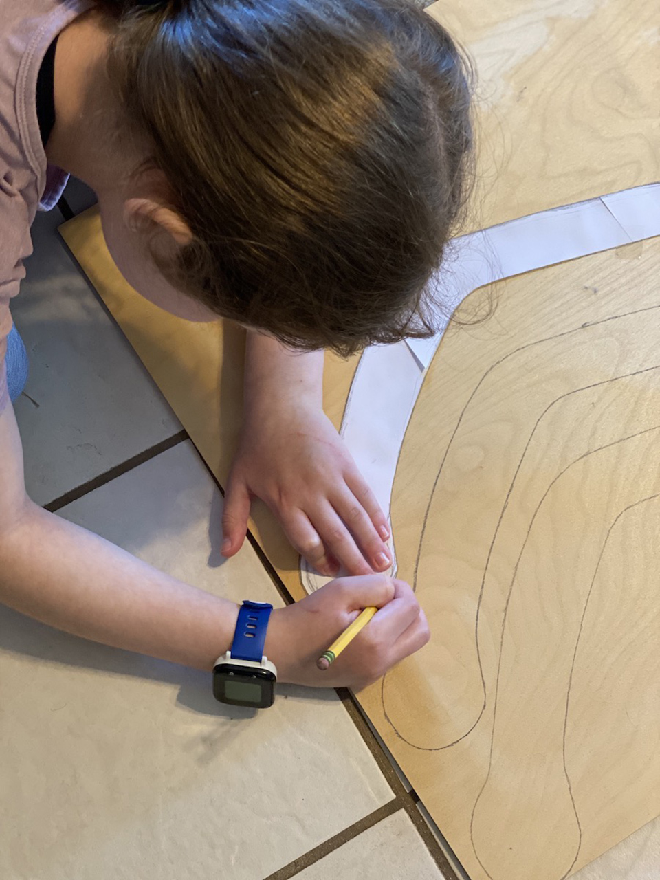 Anna traces her wing template onto plywood