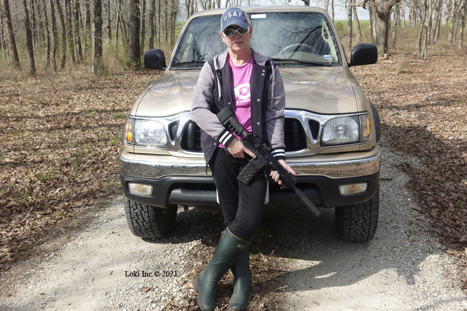 Barb with AR pistol suppressed in front of Tacoma truck Saker 556 ASR