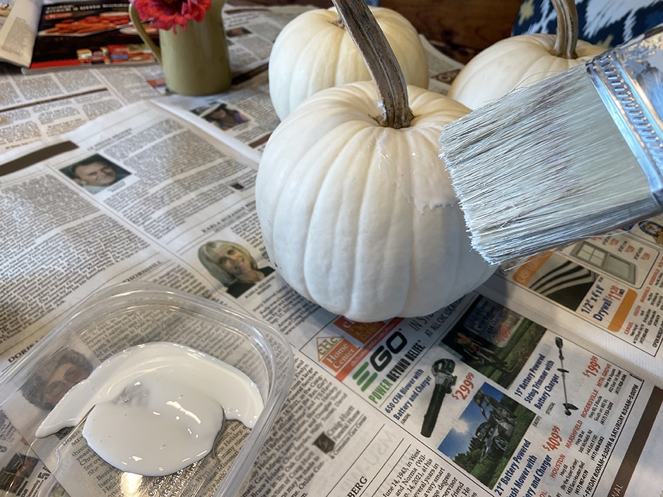 Applying the Mod Podge to the pumpkins