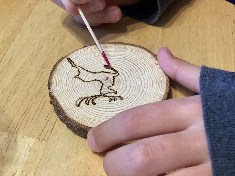 Rose applies pokeberry stain to her reindeer design on her Wood Christmas Ornaments