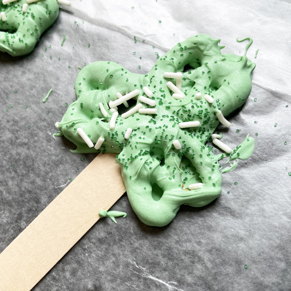 Shamrock Pretzel Treats adding sprinkles