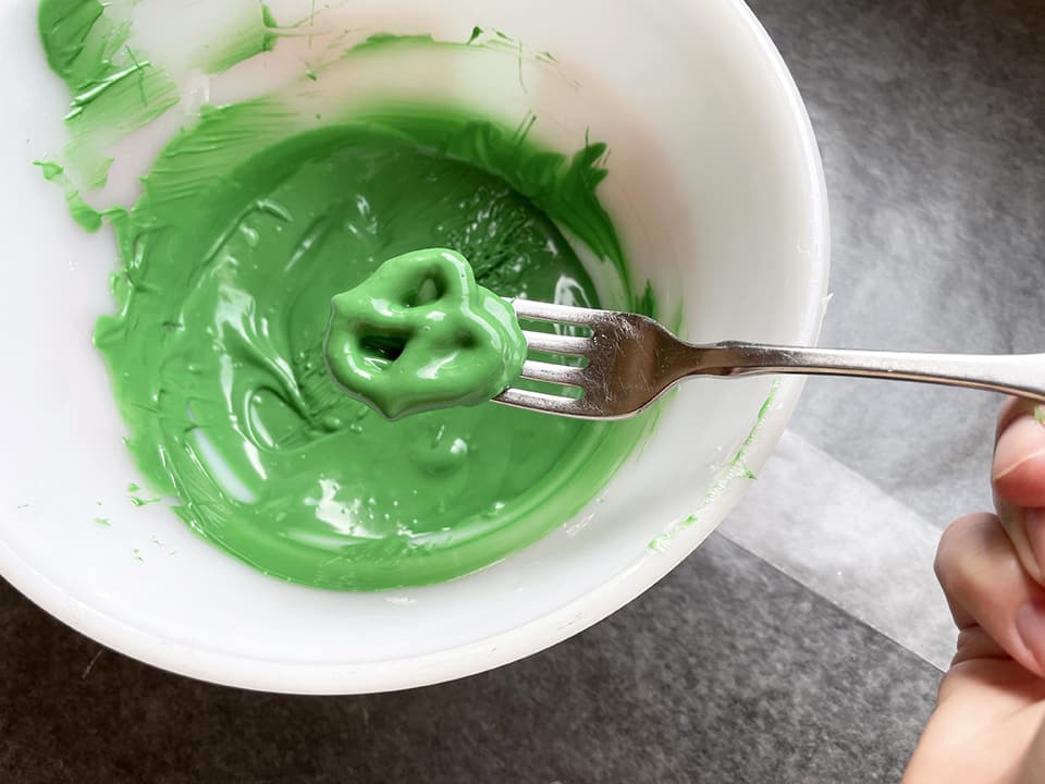 Shamrock Pretzel Treats dipping the pretzels