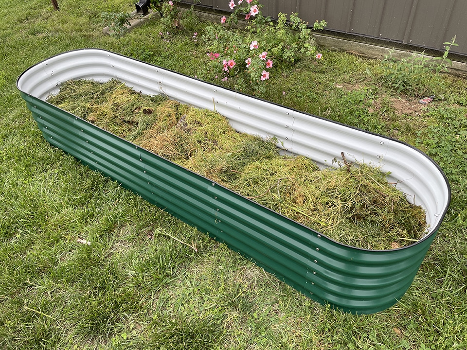 Raised Garden Bed Adding Lawn Clippings