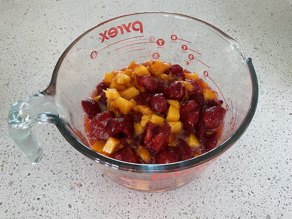 Adding chopped strawberries to the jam