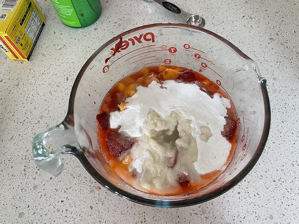 Adding sugar pectin and lemon juice to jam mixture