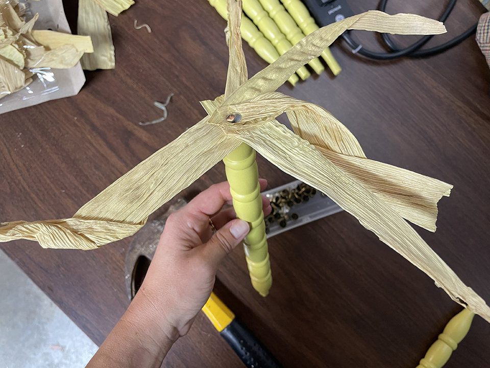 Tacking the corn husks in place