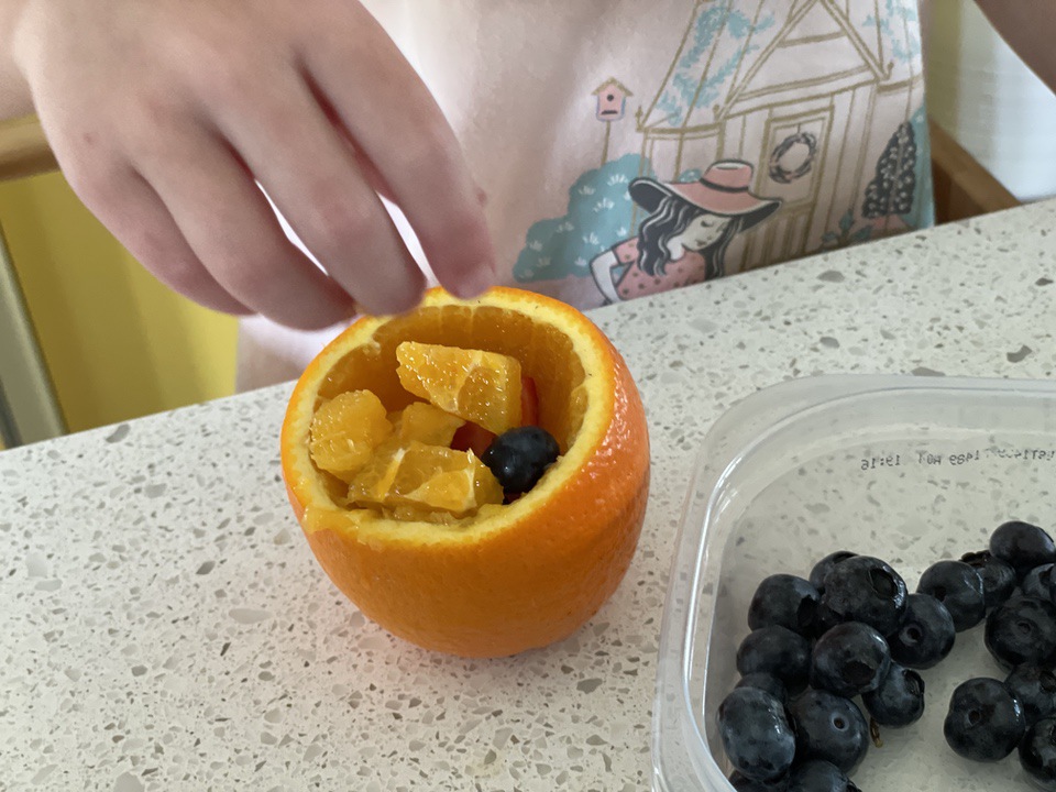 Filling jack-o-lantern fruit cup