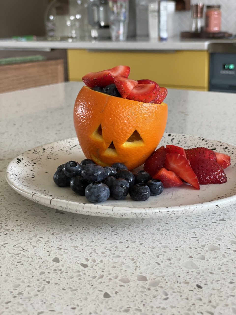 jack-o-lantern fruit cup on plate