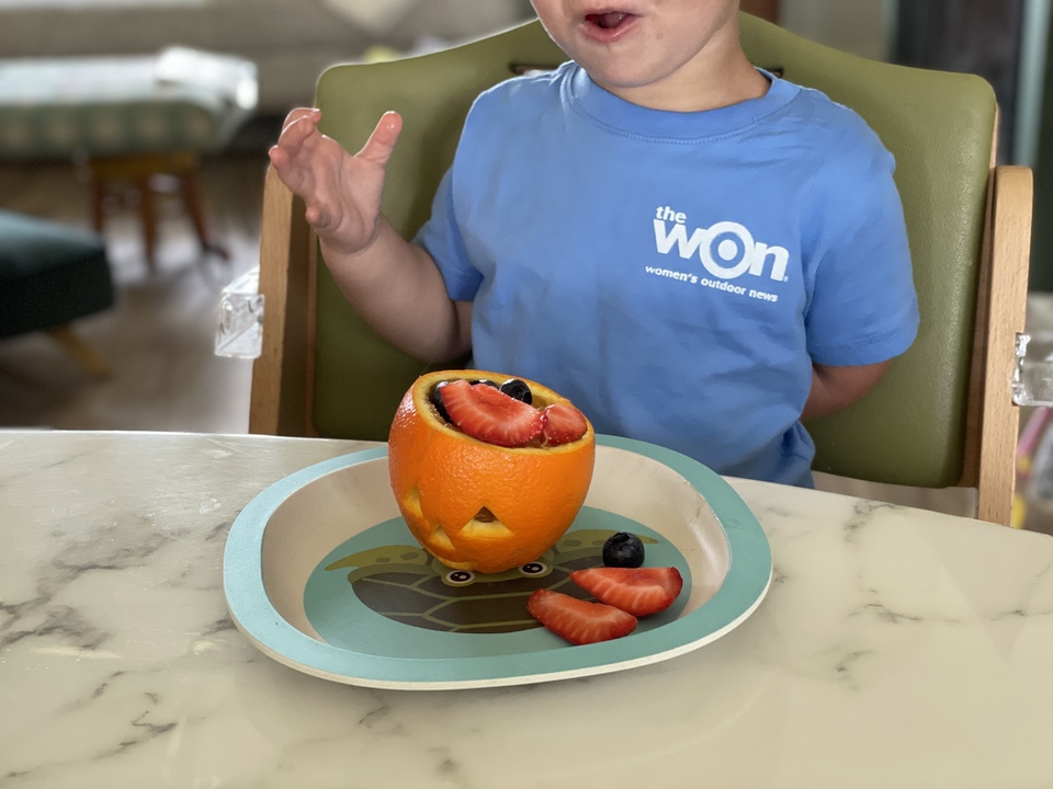 toddler with jack-o-lantern fruit cup
