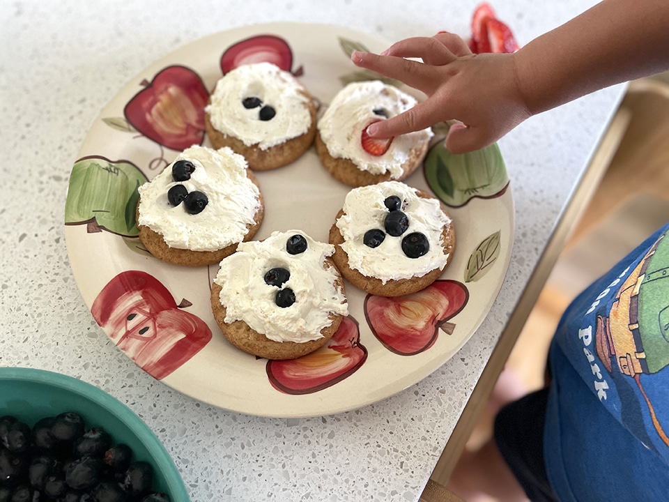 Decorating the mini fruit pizzas