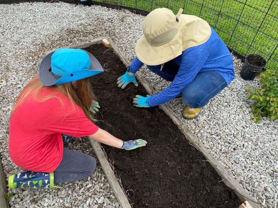 Anna and Rose learning how to build a raised bed