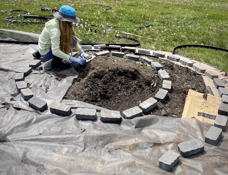 Rose lays bricks to determine the size and shape of the spiral.