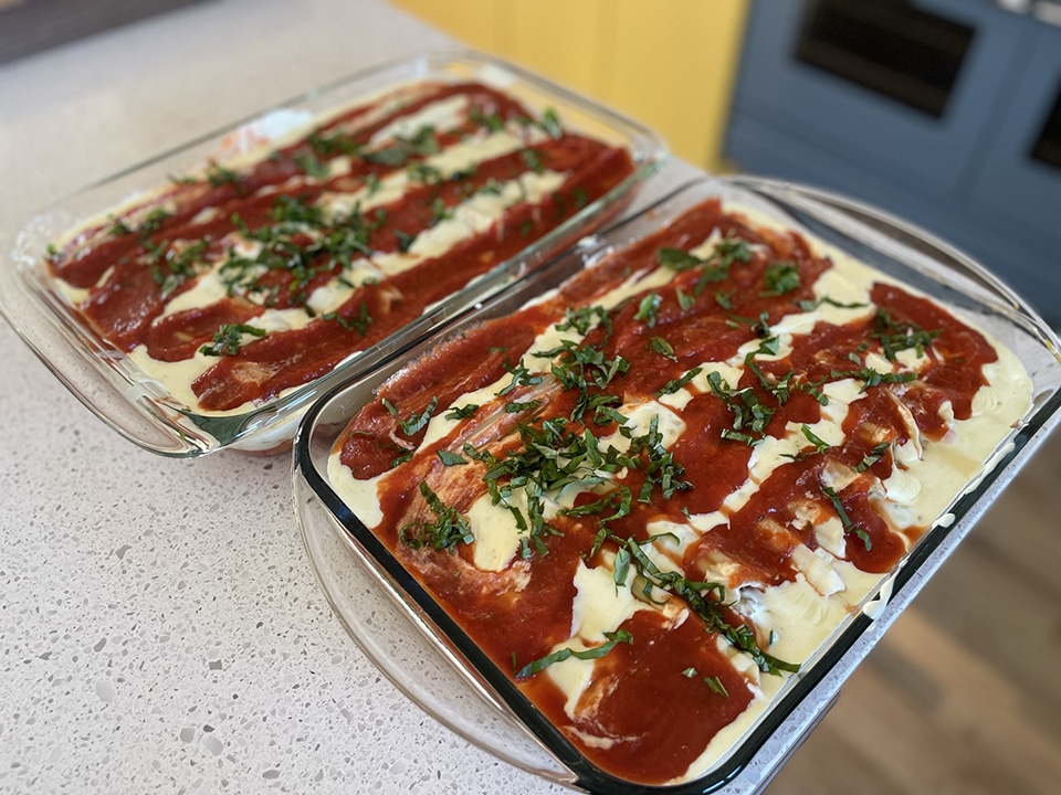 Topping manicotti with basil