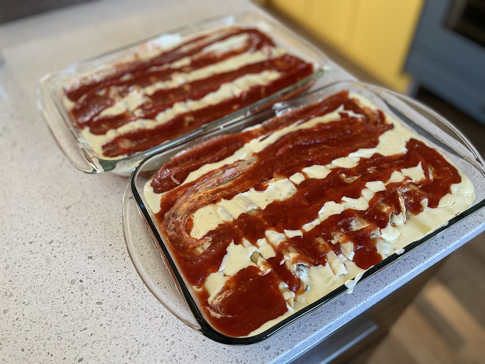 Topping manicotti with red sauce