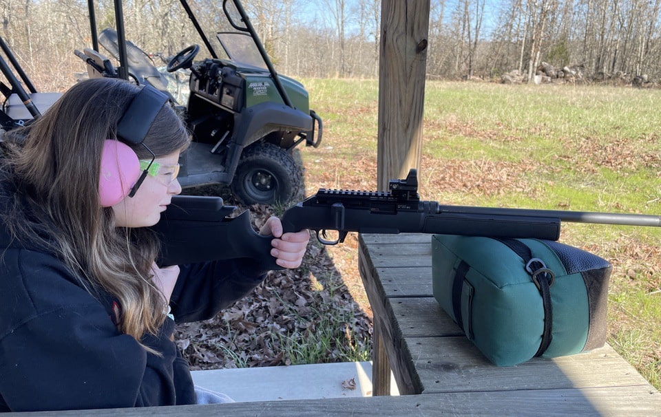 Girl looking thru red dot on Hammerli