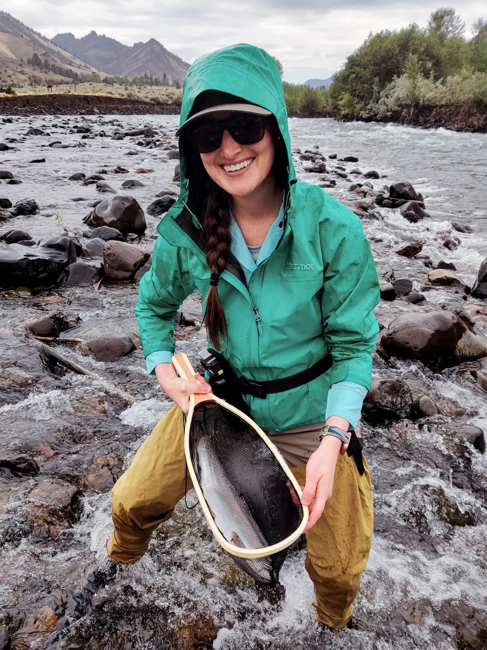woman-with-rainbow-trout-in-net-in-river
