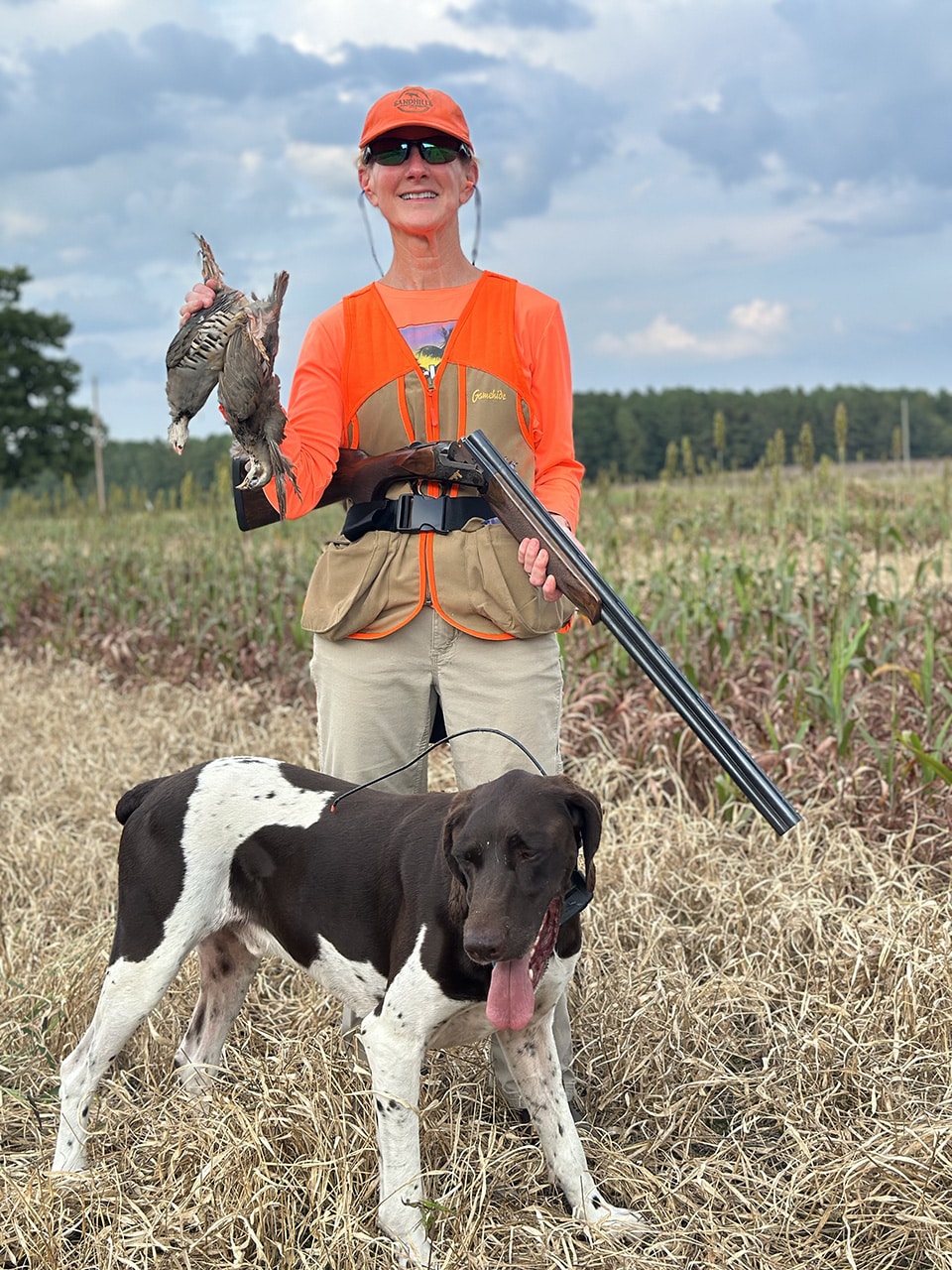 Woman in field shotgun dog birds