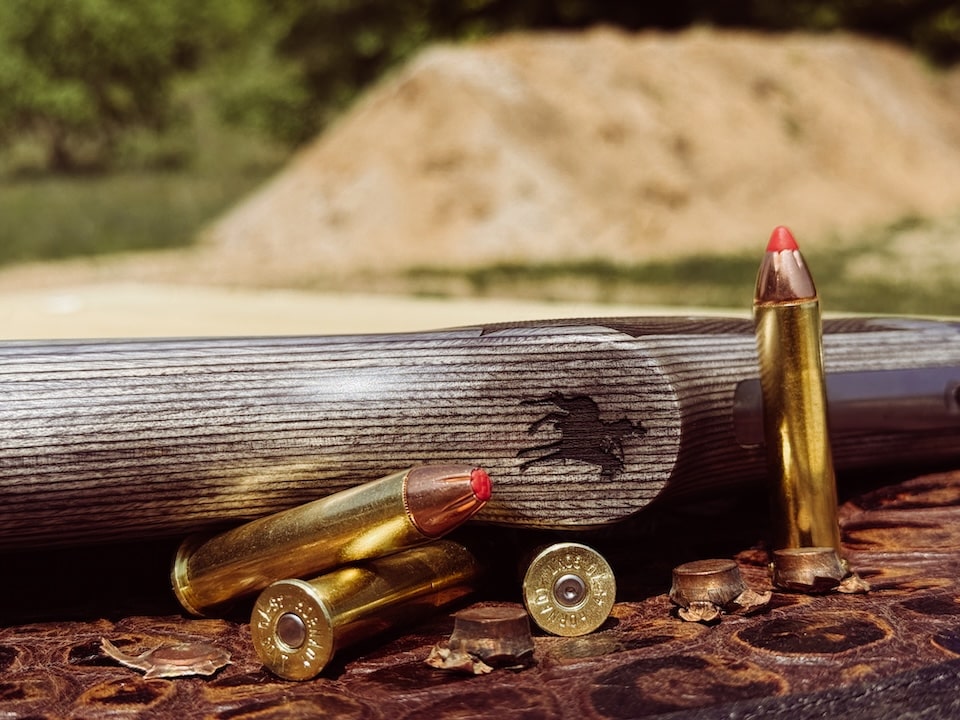 Picture of Marlin emblem on gripcap with ammunition on bench .45-70 SBL 1895