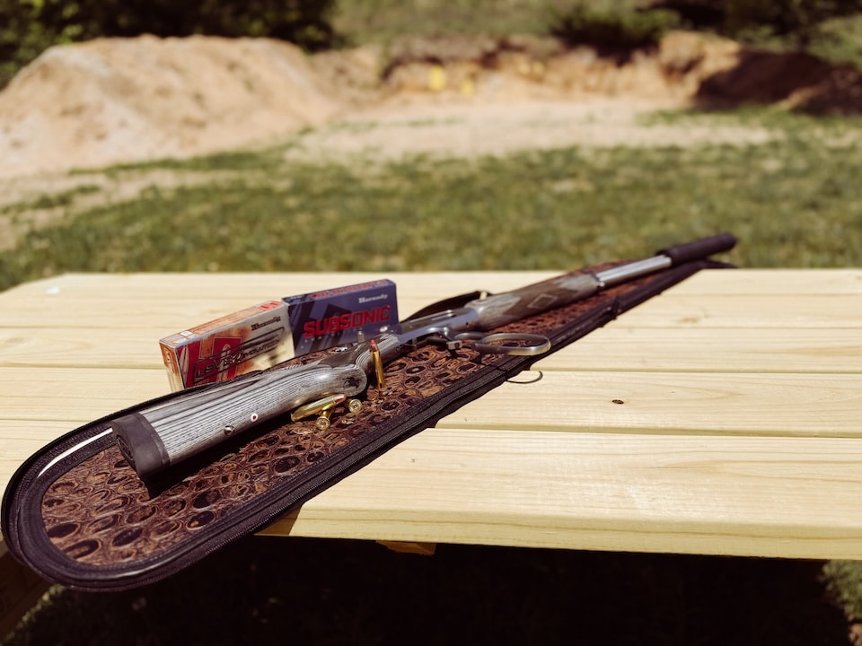 Rifle on bench with ammunition and suppressor .45-70 SBL 1895