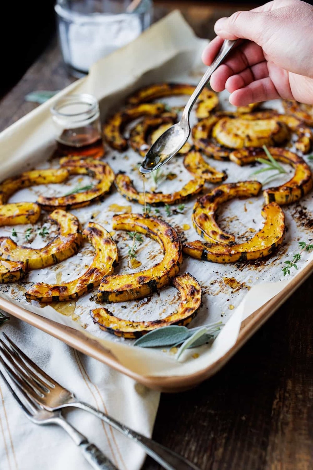 drizzling-maple-syrup-over-roasted-delicata-squash-with-herbs